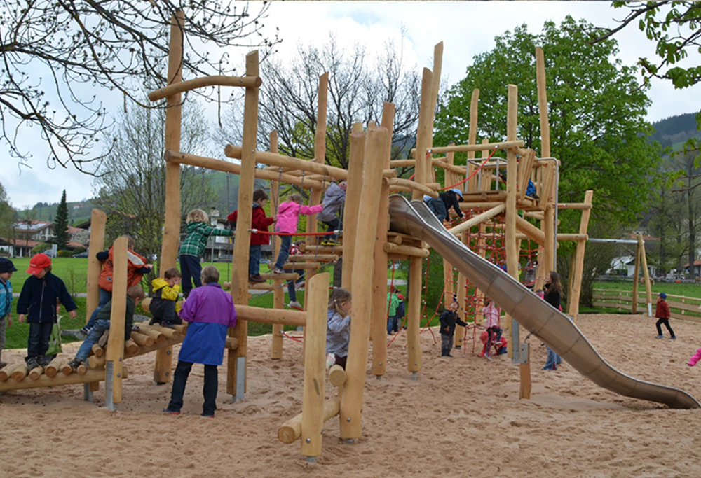 Kinder auf einem naturnahen Holzspielplatz